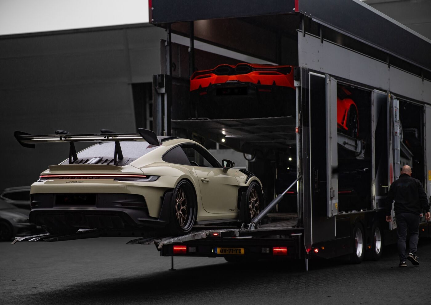 Sportwagen wird auf dem Betriebsgelände in einen geschlossenen Doppelstock-Transporter verladen