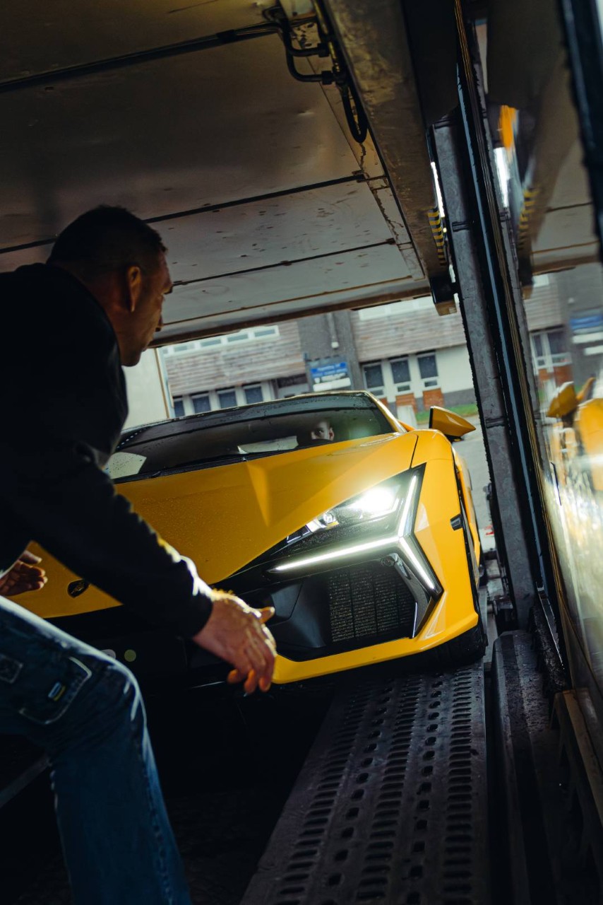 Sportwagen wird vorsichtig in einen geschlossenen Trailer gefahren