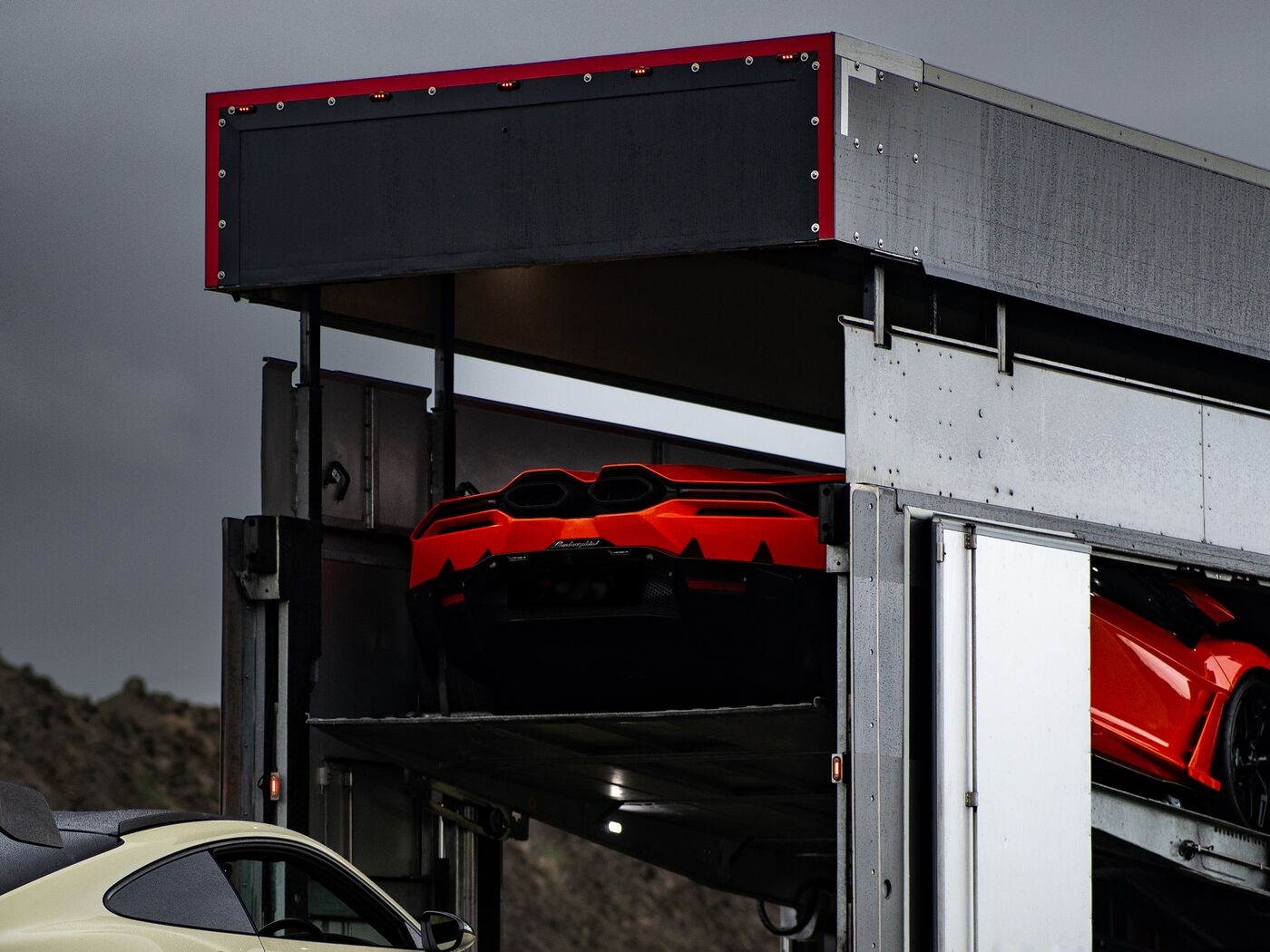 Lamborghini auf dem Oberdeck eines geschlossenen Transporters mit geöffneter Seitentür